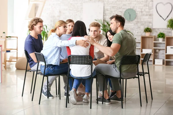 Människor lugnande kvinna vid grupp terapi session — Stockfoto