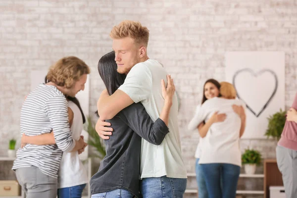 People hugging at group therapy session