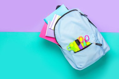 Okul malzemeleri ile renk arka plan üzerinde sırt çantası
