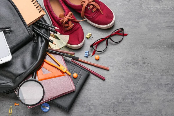 Verschillende school briefpapier, schoenen en rugzak op grijze achtergrond — Stockfoto