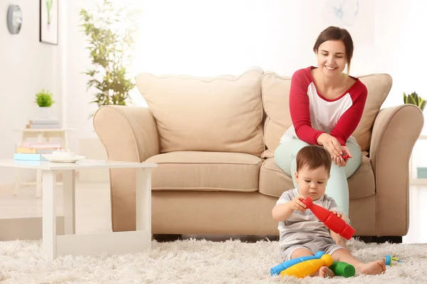 Mãe e bonito menino brincando com brinquedos em casa — Fotografia de Stock