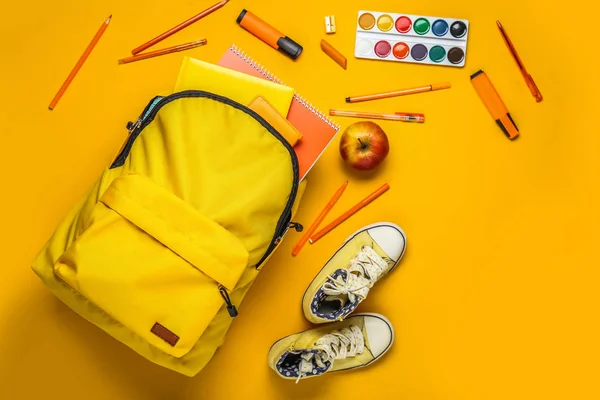 Mochila escolar con papelería y zapatos sobre fondo de color —  Fotos de Stock