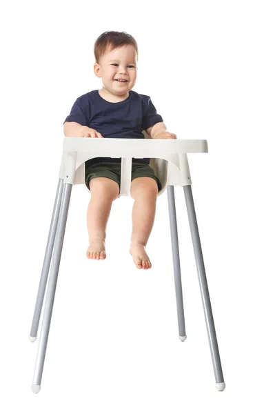 Cute baby boy sitting in high chair against white background — Stock Photo, Image