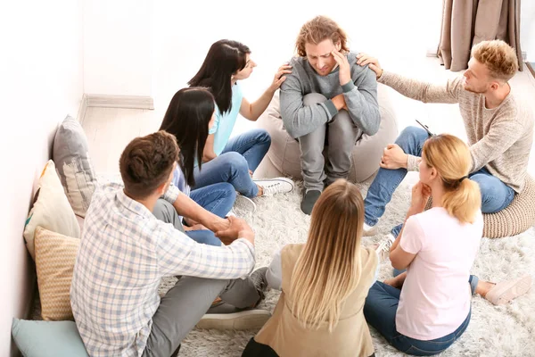 Personas calmando al hombre en la sesión de terapia de grupo — Foto de Stock
