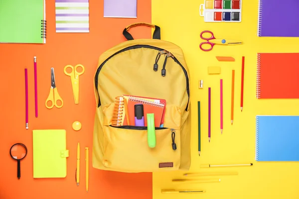 Backpack with school supplies on color background — Stock Photo, Image
