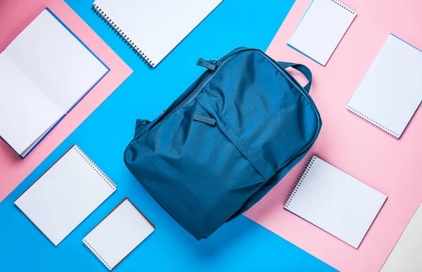 Mochila escolar con cuadernos sobre fondo de color —  Fotos de Stock