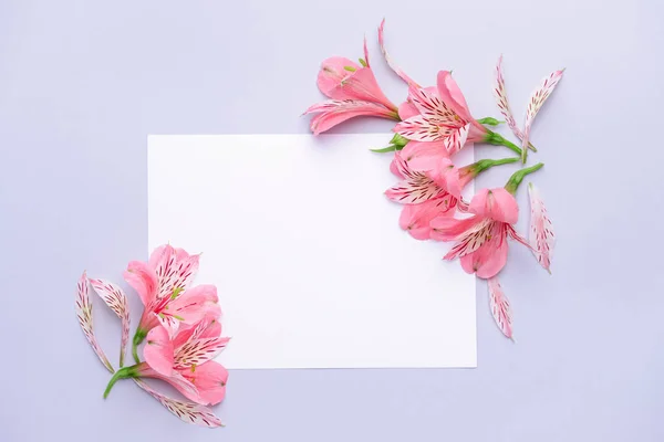 Vackra fräscha blommor och blankt kort på ljus bakgrund — Stockfoto
