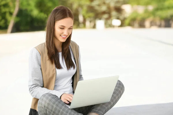 Vacker kvinnlig student med laptop utomhus — Stockfoto