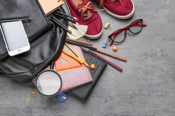 Verschillende school briefpapier, schoenen en rugzak op grijze achtergrond — Stockfoto