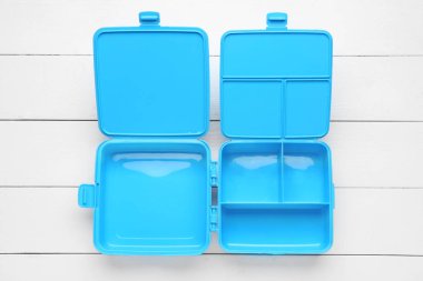 Beyaz ahşap arka planda plastik öğle yemeği kutusu