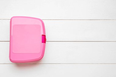 Beyaz ahşap arka planda plastik öğle yemeği kutusu