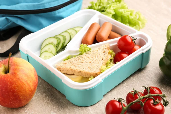 Lunch box with tasty food on wooden background — Stock Photo, Image