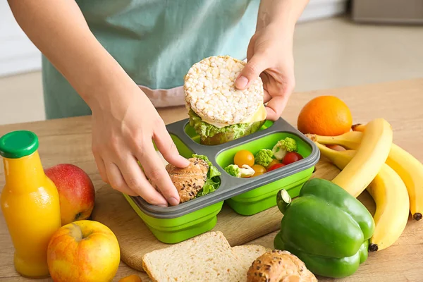 Woman packing tasty lunch in box — Stock Photo, Image