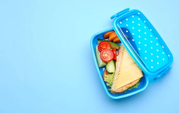 Lunchbox mit leckerem Essen auf farbigem Hintergrund — Stockfoto