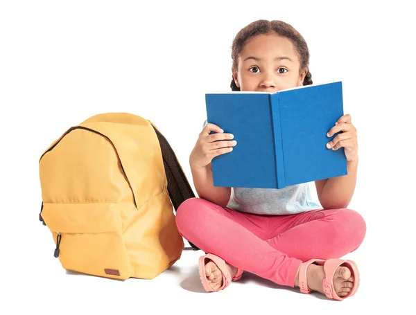 Entzückende kleine afrikanisch-amerikanische Schülerin liest Buch auf weißem Hintergrund — Stockfoto