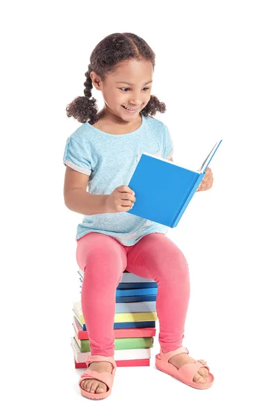 Adorable little African-American schoolgirl reading book on white background — Stock Photo, Image
