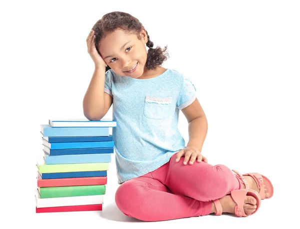 Adorable colegiala afroamericana con libros sobre fondo blanco — Foto de Stock