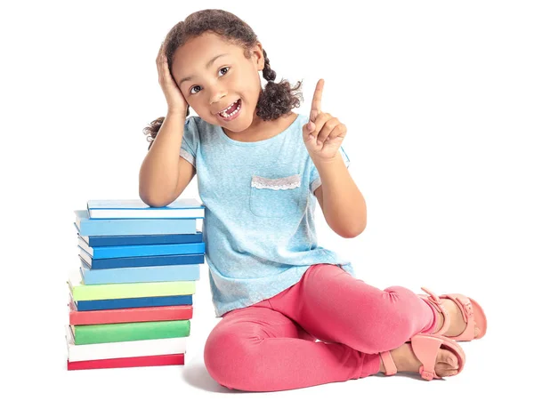 Adorable colegiala afroamericana con libros y el dedo índice levantado sobre fondo blanco — Foto de Stock