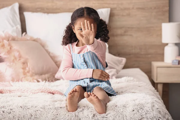 Sad little African-American girl showing stop gesture at home — Stock Photo, Image