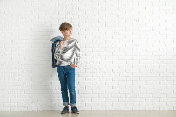 Stylish boy in jeans clothes near white brick wall — Stock Photo, Image