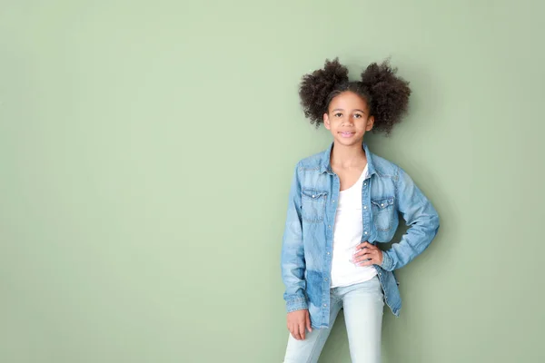 Elegante ragazza afro-americana in jeans vestiti su sfondo di colore — Foto Stock