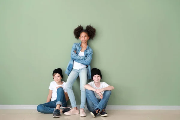 Stylische Kinder in Jeans-Klamotten nahe der Farbwand — Stockfoto