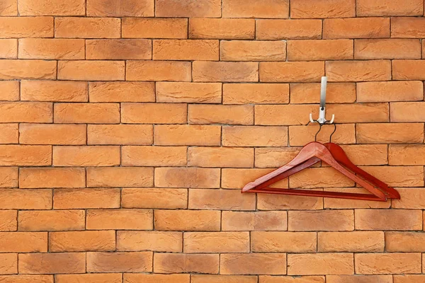 Clothes hangers on brick wall — Stock Photo, Image