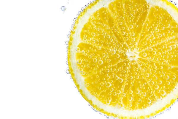 Спелый ломтик лимона в воде, крупным планом — стоковое фото