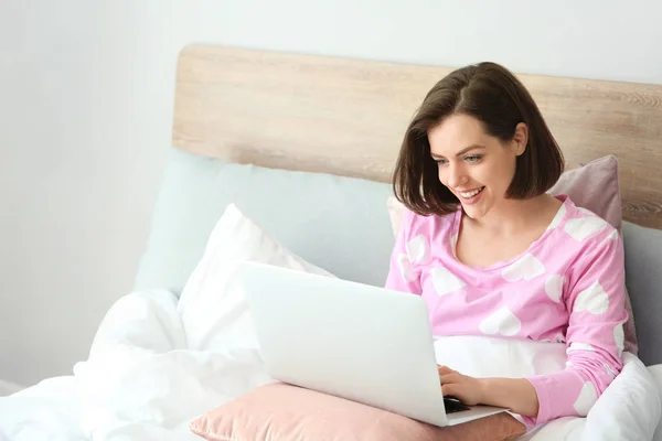 Morning of beautiful young woman with laptop in bed — Stock Photo, Image