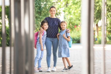 Sevimli küçük çocuklar anneleriyle okula gidiyor