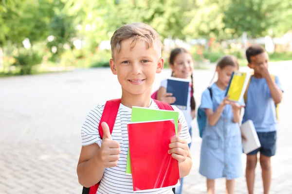 Cute little schoolboy with classmates outdoors — Stock Photo, Image