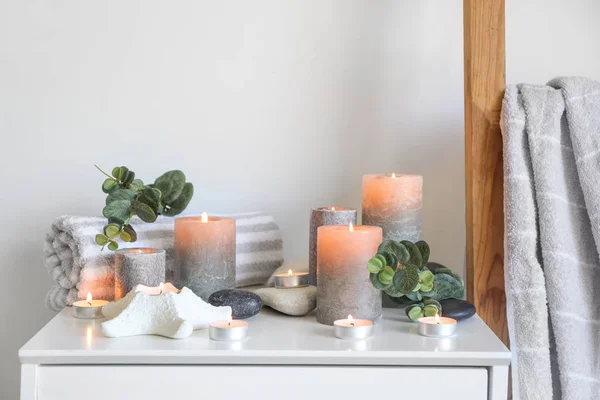 Красивые горящие свечи с эвкалиптом на столе в комнате — стоковое фото