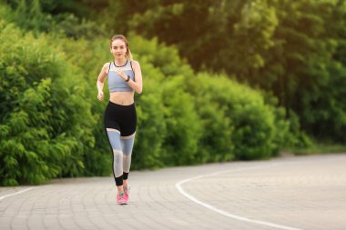 Parkta çalıştıran sportif genç kadın