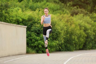 Parkta çalıştıran sportif genç kadın