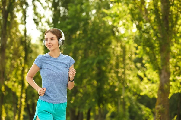 Sporty young woman running in park — Stock Photo, Image