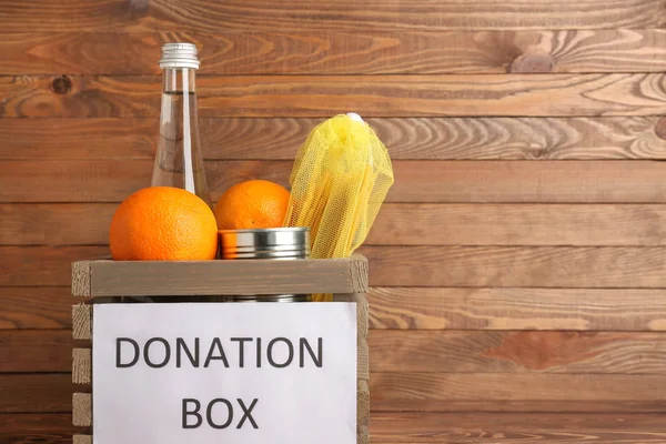 Box med donation mat på trä bakgrund — Stockfoto