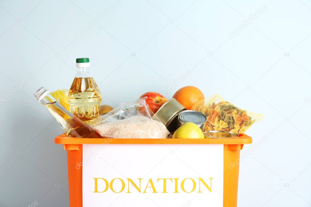 Box with donation food on light background