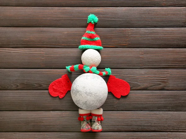 Снеговик из рождественского декора на деревянном фоне — стоковое фото