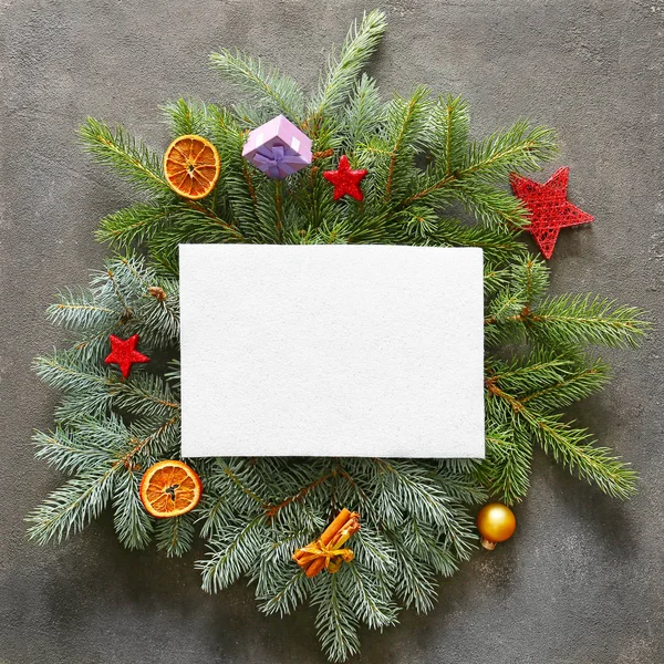 Vánoční věnec a prázdná karta na šedém pozadí — Stock fotografie
