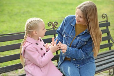 Anne öğretmek ona sağır mute kızı için kullanmak işaret dil açık havada