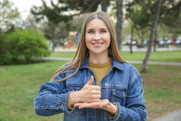 Young deaf mute woman using sign language outdoors — Stock Photo, Image
