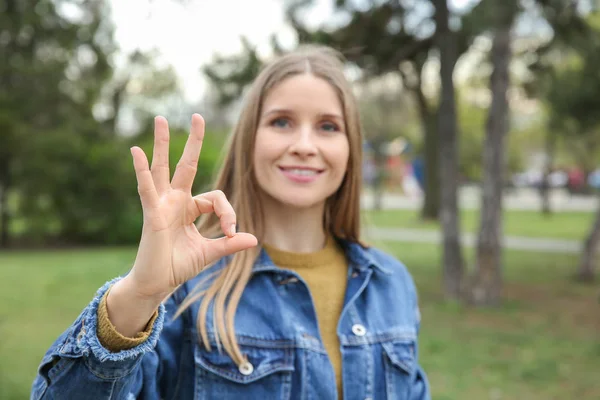 Young deaf mute woman using sign language outdoors — Stock Photo, Image