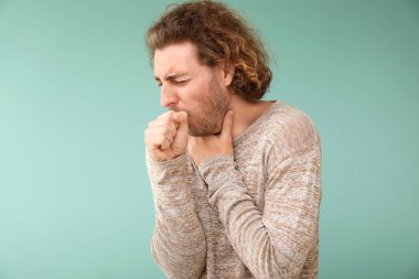 Renkli arka planda öksüren genç adam