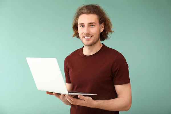 Man programmeur met laptop op kleur achtergrond — Stockfoto