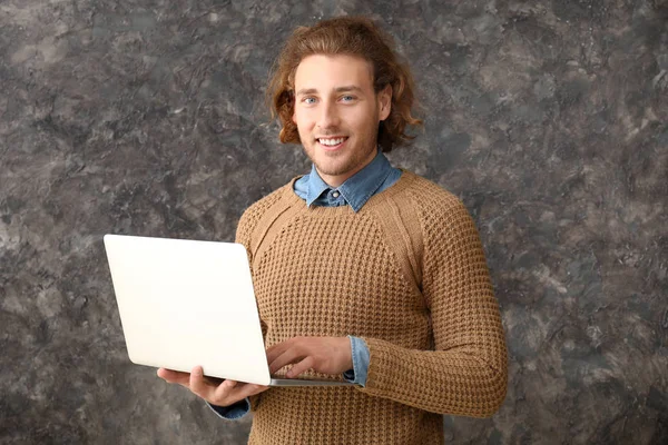 Mannelijke programmeur met laptop op grunge achtergrond — Stockfoto