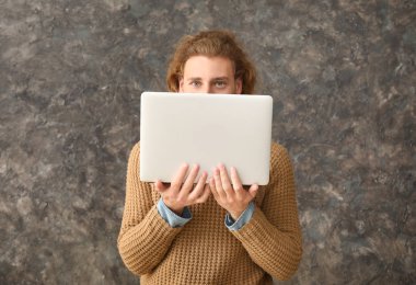 Grunge arka planda dizüstü bilgisayar ile erkek programcı