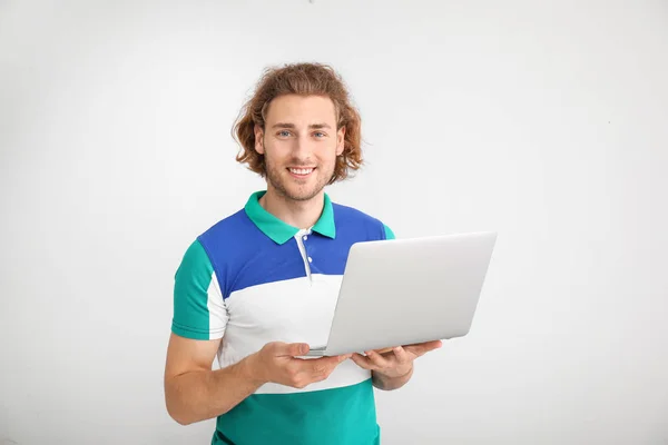 Männlicher Programmierer mit Laptop auf hellem Hintergrund — Stockfoto
