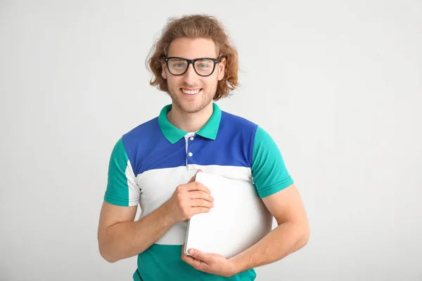 Male programmer with laptop on light background — Stock Photo, Image