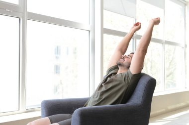 Evde koltukta dinlenmek yakışıklı adam