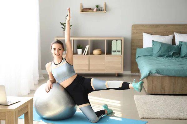 Jovem fazendo exercício com fitball em casa — Fotografia de Stock